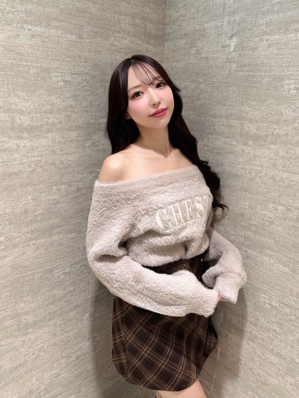 ピンク系のニット/セーター、ブラウン系のスカート、ブラウン系のブーツを着用したレディースの秋コーディネートの5枚目の写真