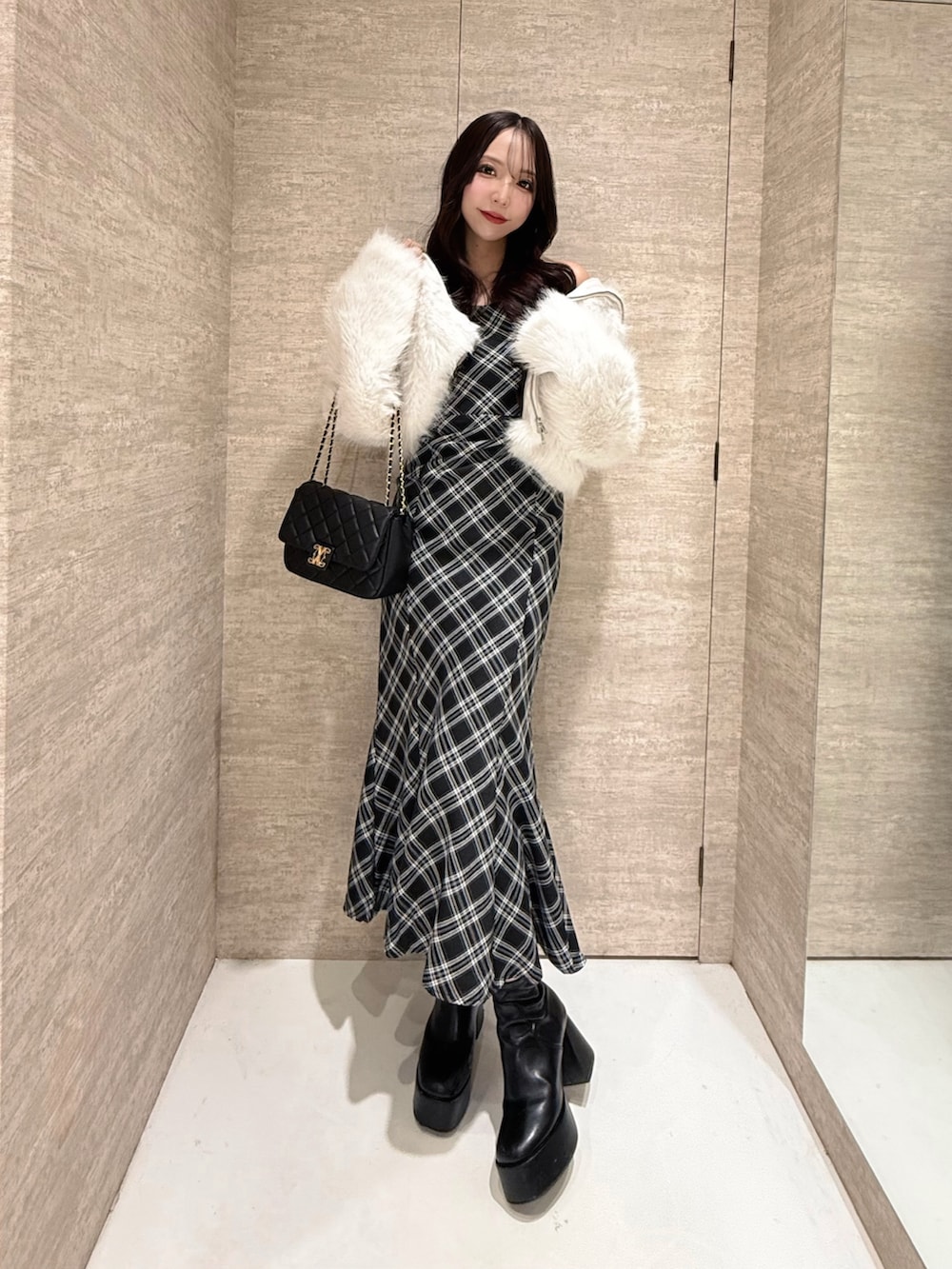 ホワイト系のブルゾン、ブラック系のワンピース、ブラック系のショルダーバッグを着用したレディースの秋コーディネートの2枚目の写真