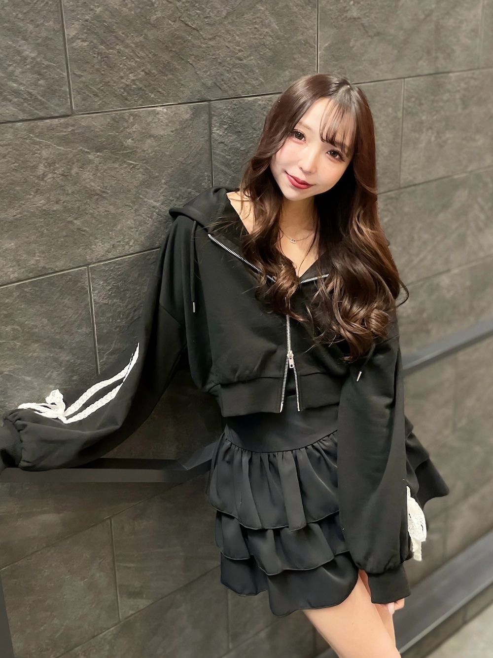 ブラック系のパーカー、ブラック系のキャミソール、ブラック系のスカートを着用したレディースの春コーディネートの3枚目の写真