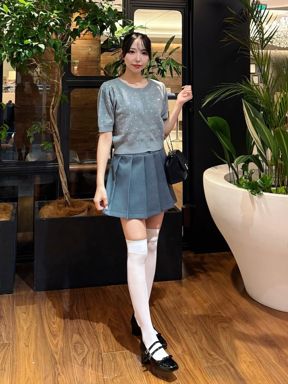 グレー系のカーディガン/ボレロ、グレー系のスカート、ブラック系のショルダーバッグを着用したレディースの秋コーディネートの3枚目の写真