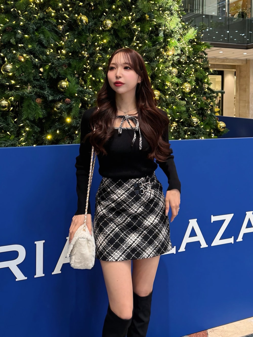 ブラック系のニット/セーター、ブラック系のスカート、ホワイト系のショルダーバッグを着用したレディースの冬コーディネートの3枚目の写真