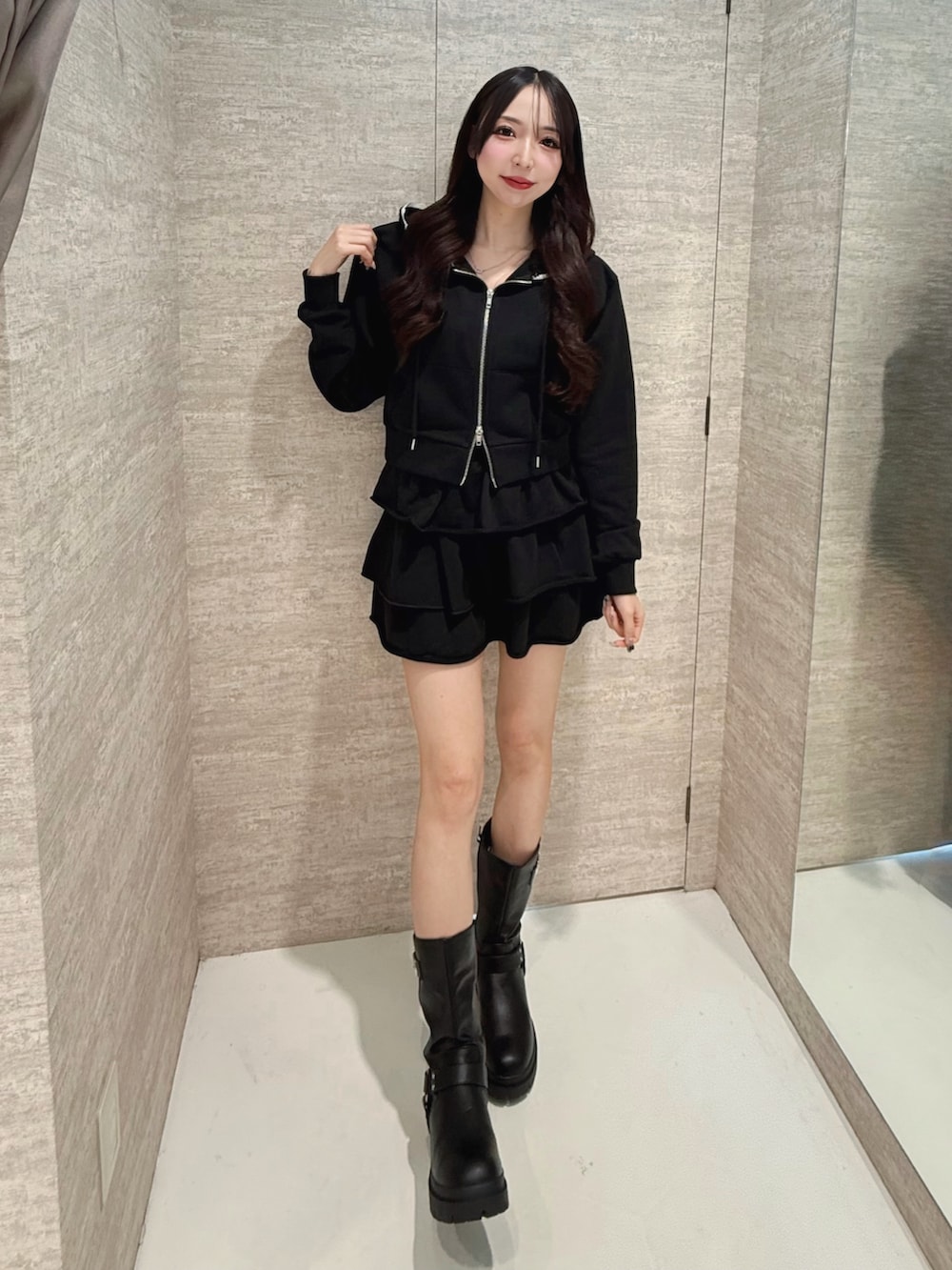 ブラック系のブーツ、ブラック系のスカート、ブラック系のパーカーを着用したレディースの秋コーディネートの2枚目の写真