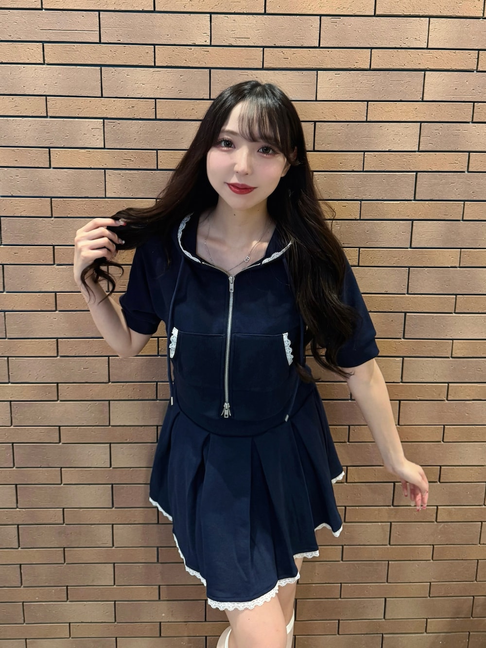 ブルー系のスカート、ブルー系のパーカー、ホワイト系のサンダルを着用したレディースの夏コーディネートの4枚目の写真