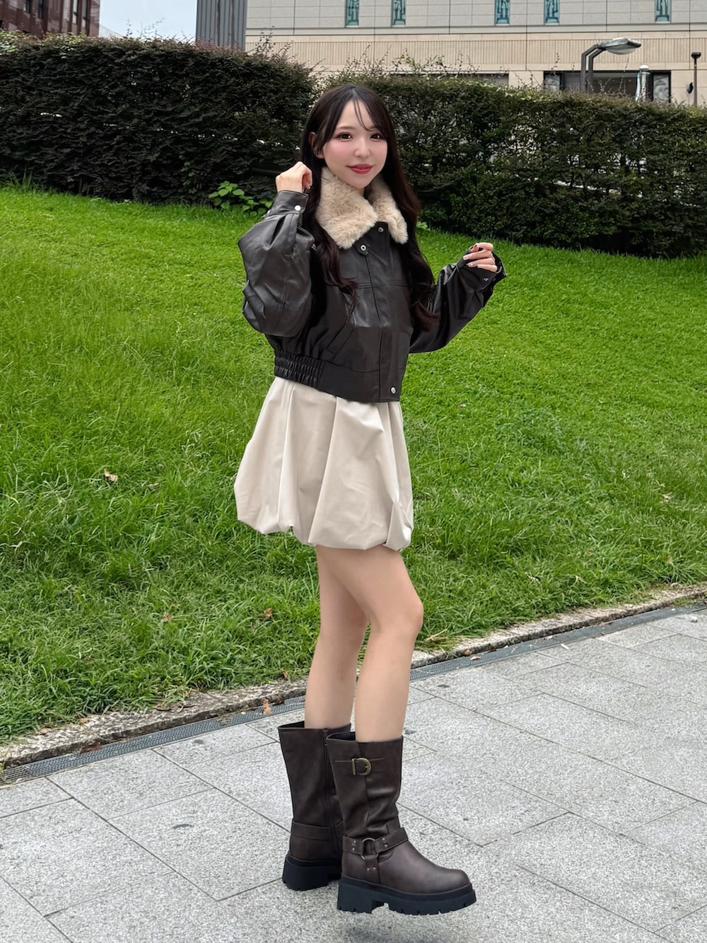 ブラック系のブルゾン、ベージュ系のスカート、ブラウン系のブーツを着用したレディースの秋コーディネートの4枚目の写真