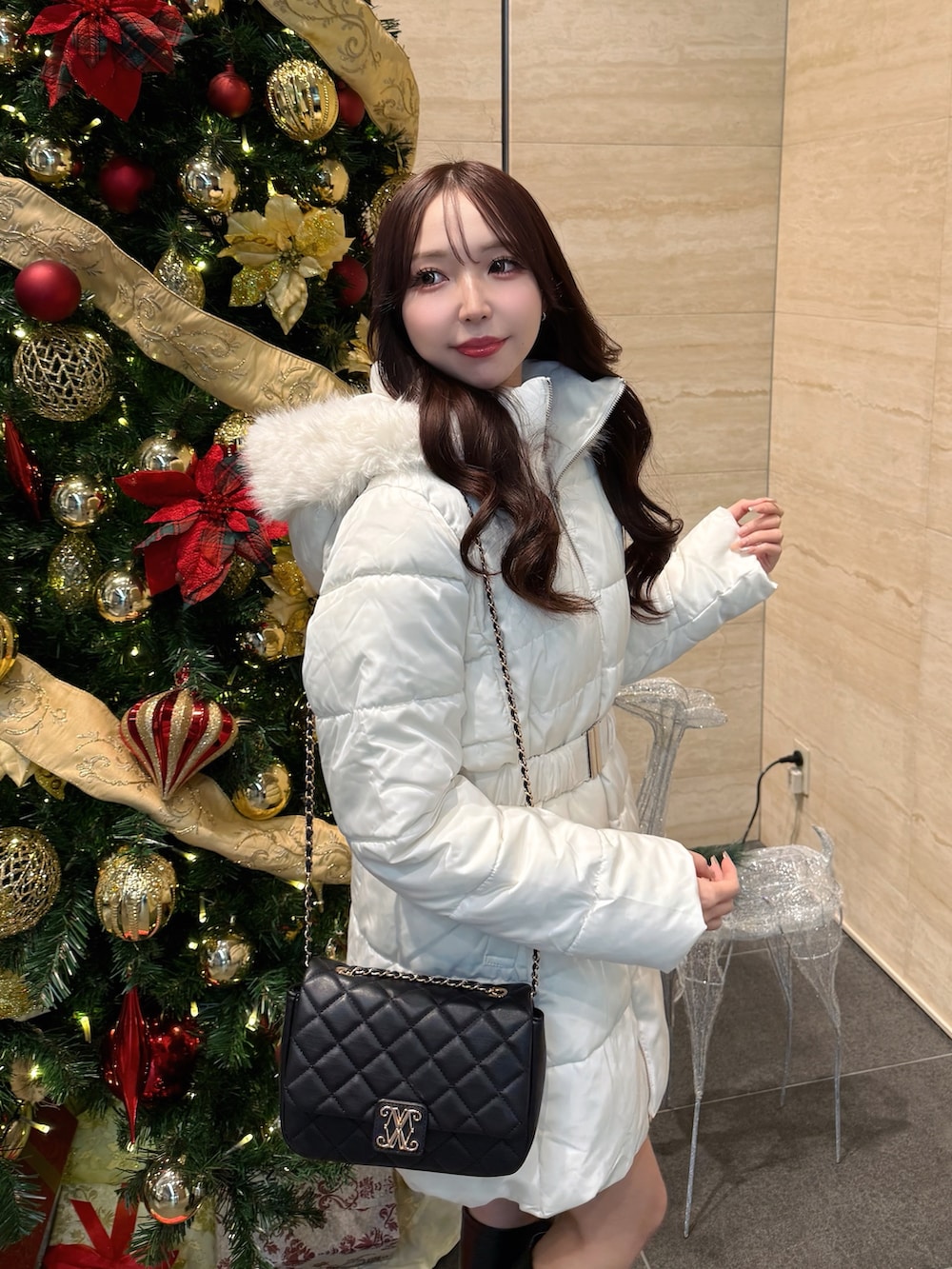 ホワイト系のダウンジャケット/コート、ブラック系のショルダーバッグを着用したレディースの冬コーディネートの4枚目の写真