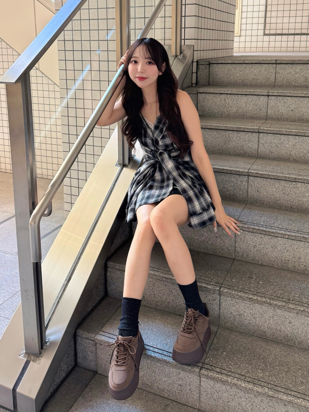 ブラック系のシャツ/ブラウス、ブラック系のスカート、ブラウン系のスニーカーを着用したレディースの秋コーディネートの4枚目の写真