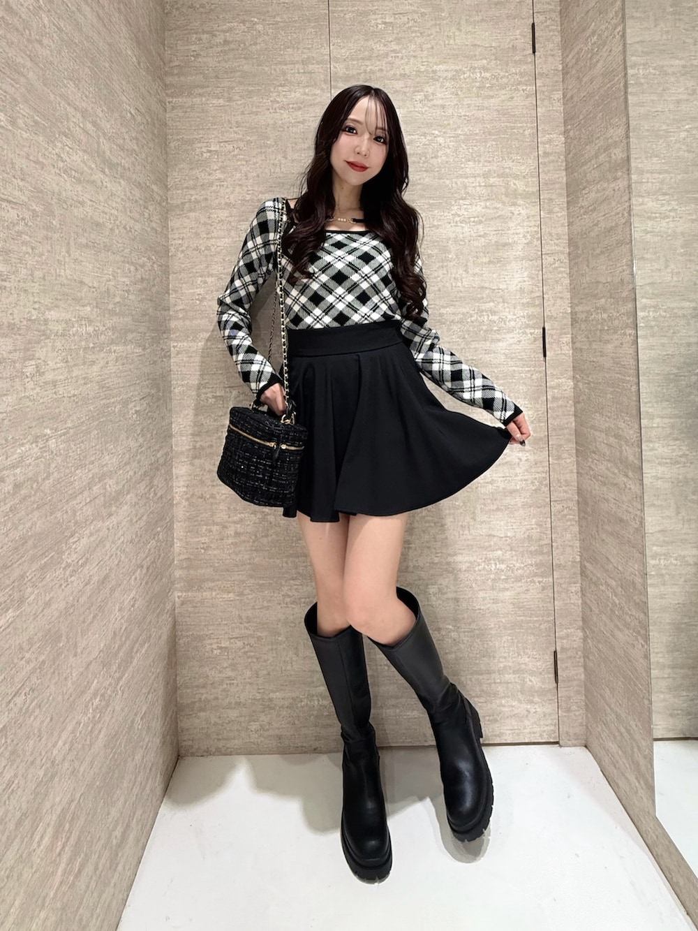 ブラック系のスカート、ブラック系のニット/セーターを着用したレディースの秋コーディネートの5枚目の写真