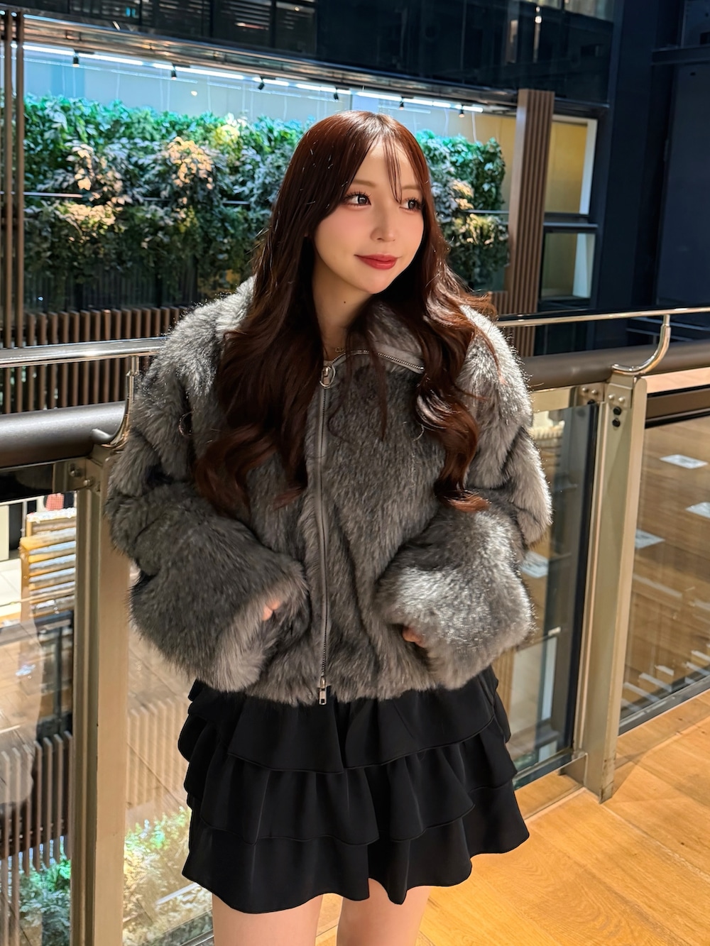 グレー系のブルゾン、ブラック系のスカートを着用したレディースの冬コーディネートの4枚目の写真