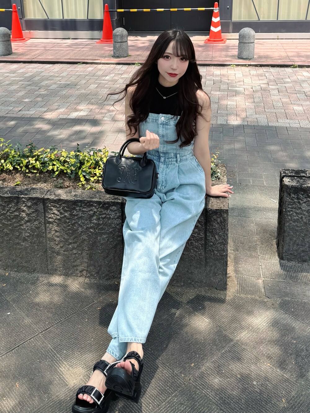 ブルー系のサロペット/オーバーオール、ブラック系のハンドバッグ、ブラック系のサンダルを着用したレディースの夏コーディネートの4枚目の写真