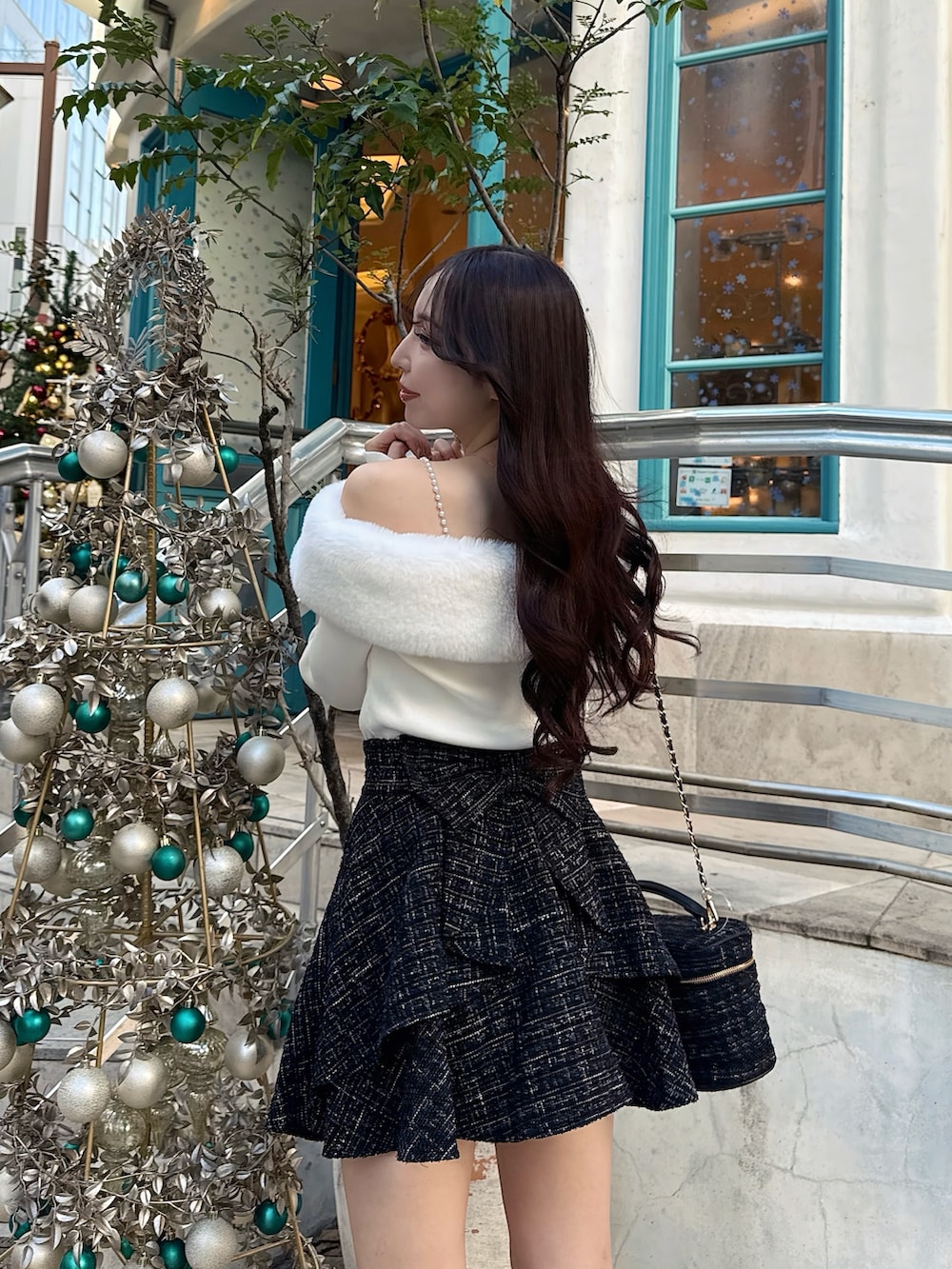 ブラック系のブーツ、ブラック系のショルダーバッグ、ブラック系のスカートを着用したレディースの秋コーディネートの6枚目の写真