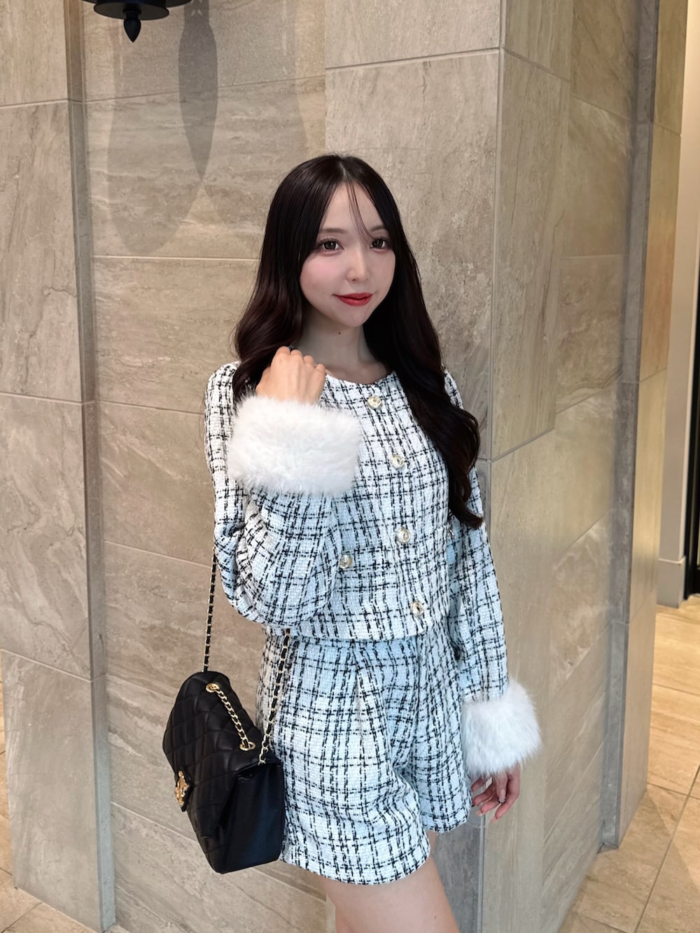 ホワイト系のノーカラージャケット、ホワイト系のその他パンツ、ブラック系のショルダーバッグを着用したレディースの秋コーディネートの6枚目の写真