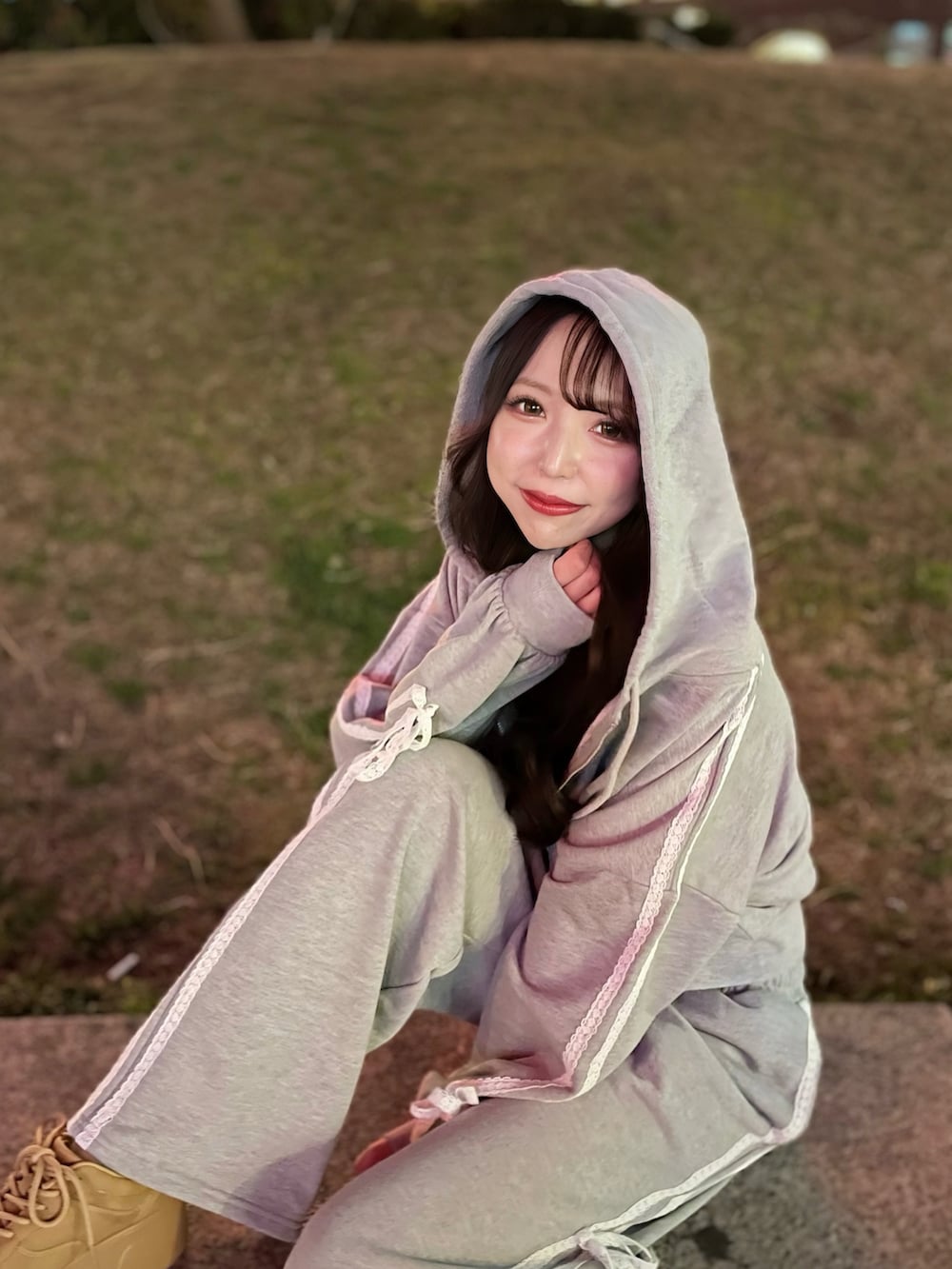 グレー系のパーカー、グレー系のスウェットパンツ、ベージュ系のスニーカーを着用したレディースの春コーディネートの3枚目の写真