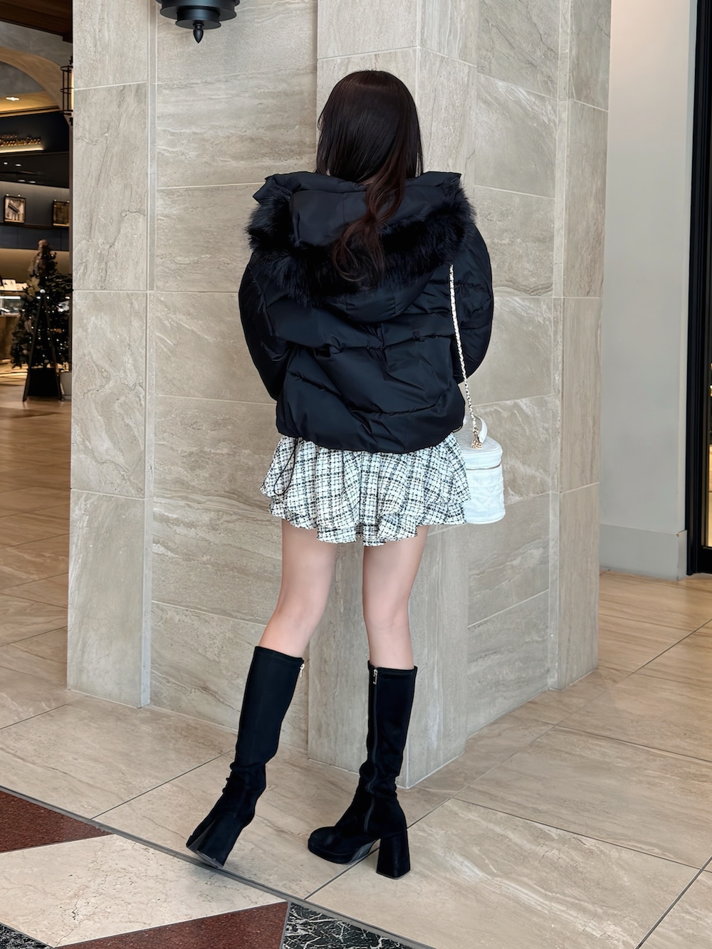 ブラック系のダウンジャケット/コート、ピンク系のニット/セーター、ホワイト系のスカートを着用したレディースの冬コーディネートの3枚目の写真