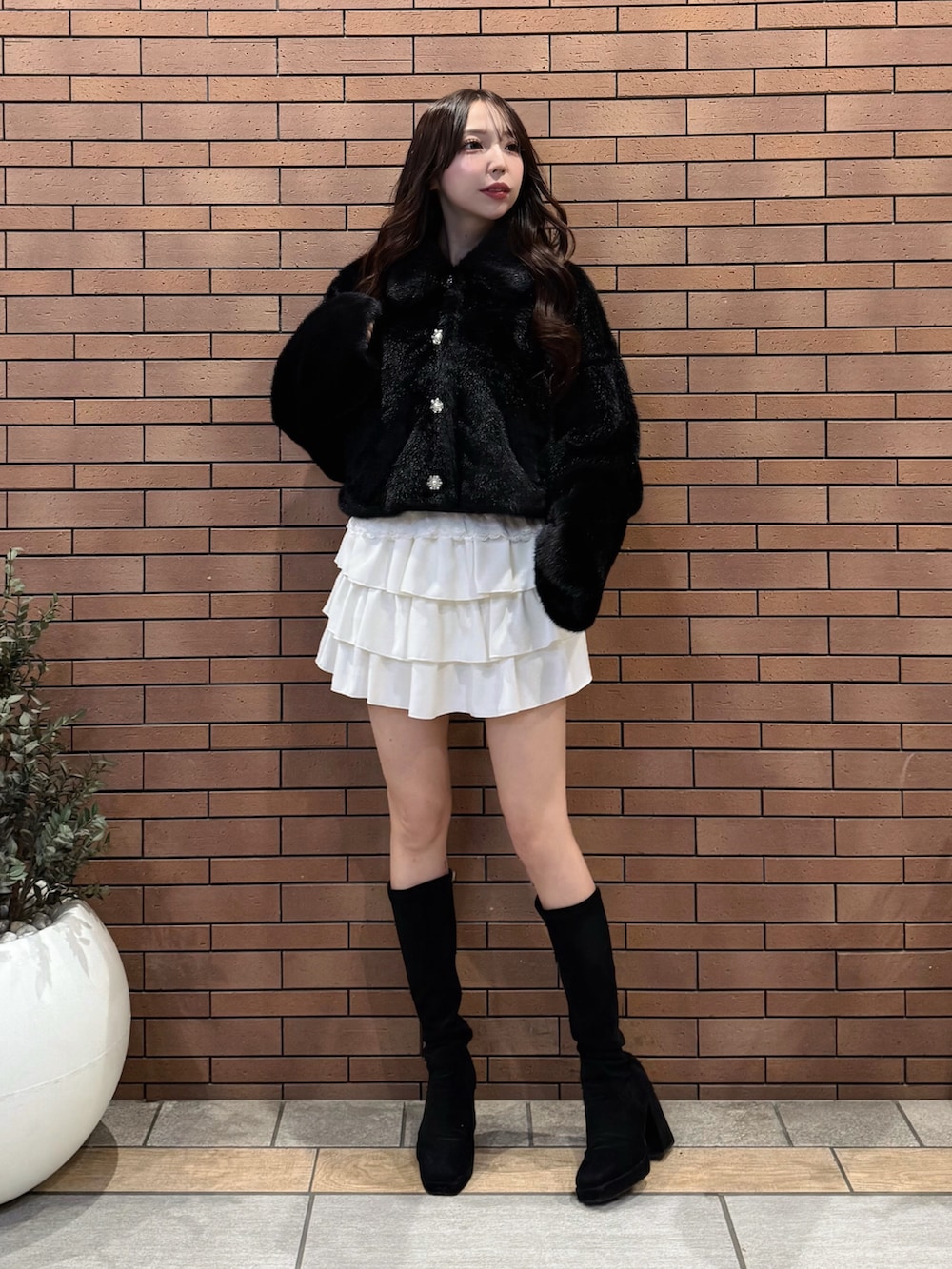 ブラック系のブルゾン、ホワイト系のスカートを着用したレディースの冬コーディネートの2枚目の写真