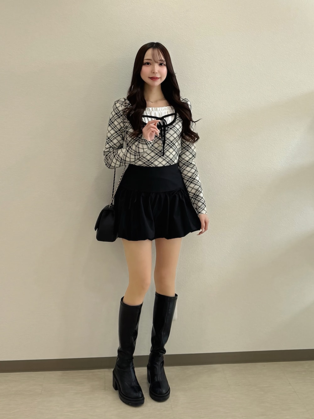 ベージュ系のニット/セーター、ブラック系のショルダーバッグ、ブラック系のスカートを着用したレディースの春コーディネートの2枚目の写真