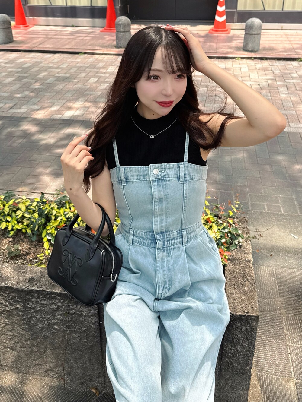 ブルー系のサロペット/オーバーオール、ブラック系のハンドバッグ、ブラック系のサンダルを着用したレディースの夏コーディネートの6枚目の写真