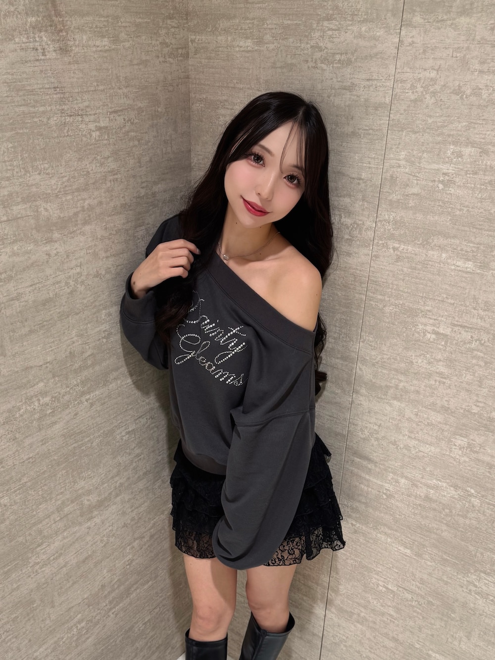 グレー系のスウェット、ブラック系のスカートを着用したレディースの秋コーディネートの2枚目の写真