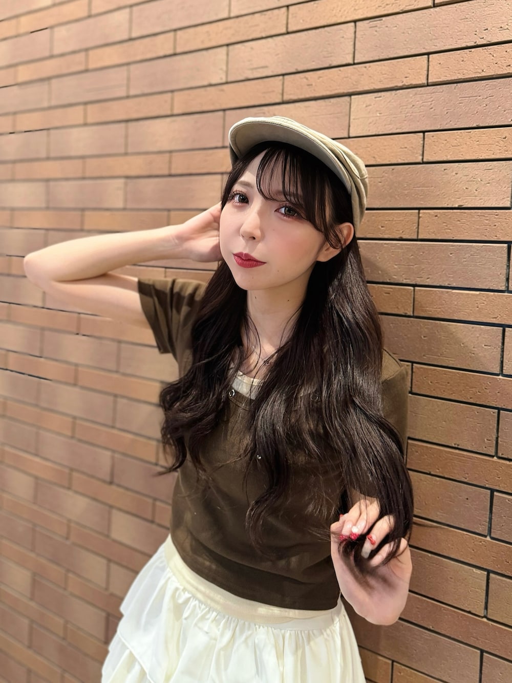 ブラウン系のTシャツ/カットソー、ホワイト系のスカート、ホワイト系のサンダルを着用したレディースの夏コーディネートの4枚目の写真