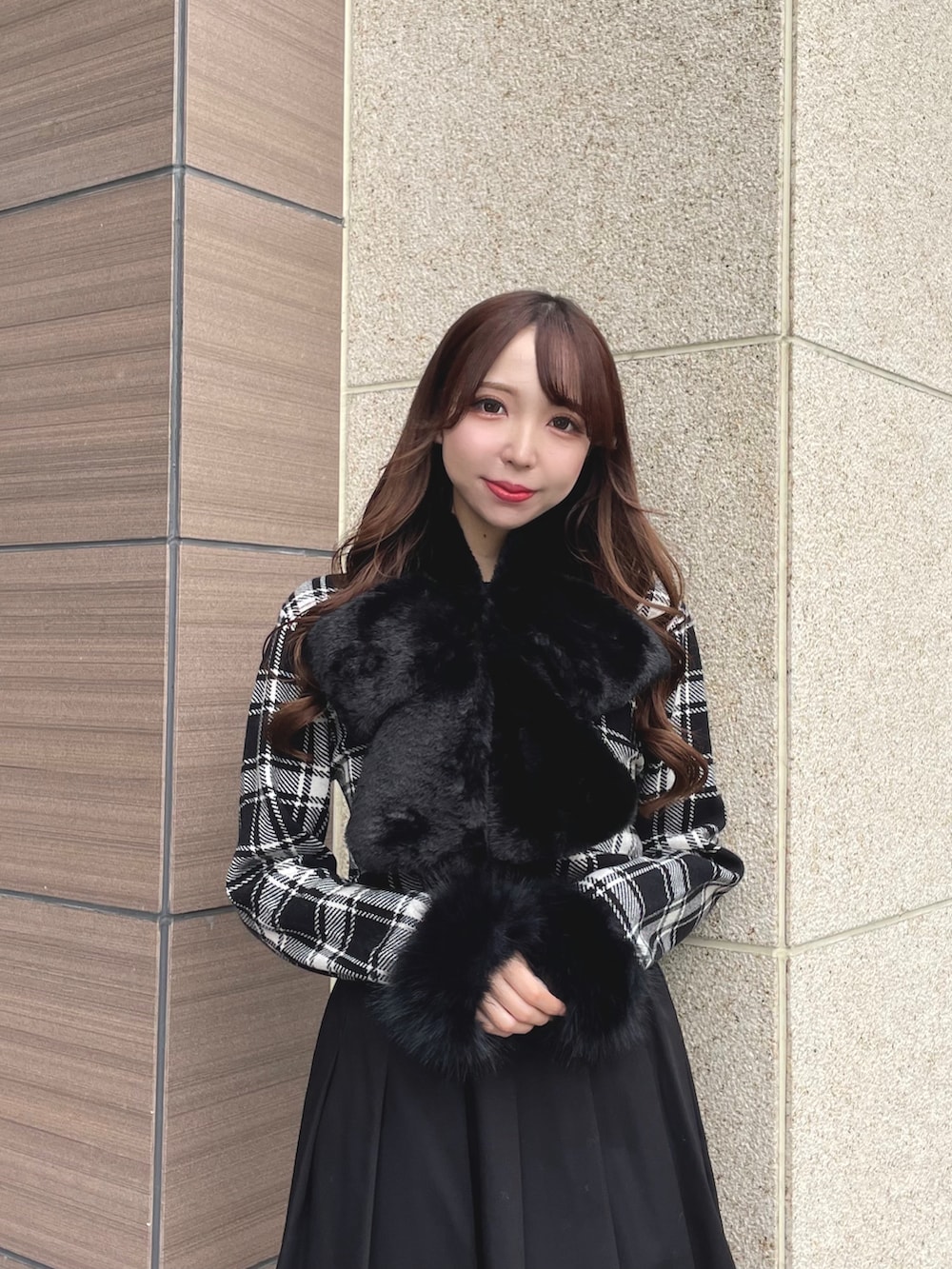 ブラック系のニット/セーター、ブラック系のスカート、ブラック系のマフラーを着用したレディースの秋コーディネートの2枚目の写真