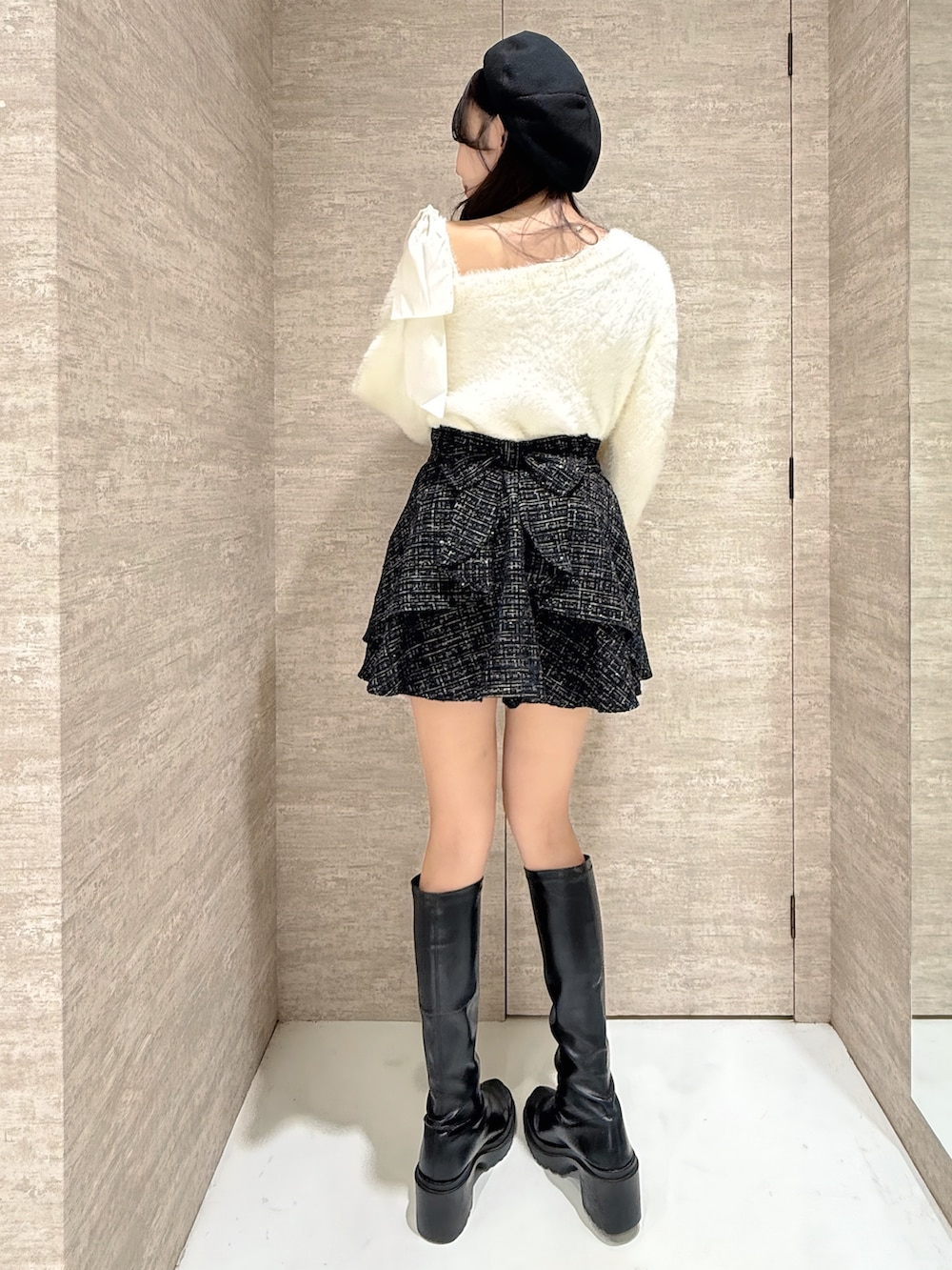 ホワイト系のニット/セーター、ブラック系のスカート、ブラック系のハンチング/ベレー帽を着用したレディースの秋コーディネートの4枚目の写真