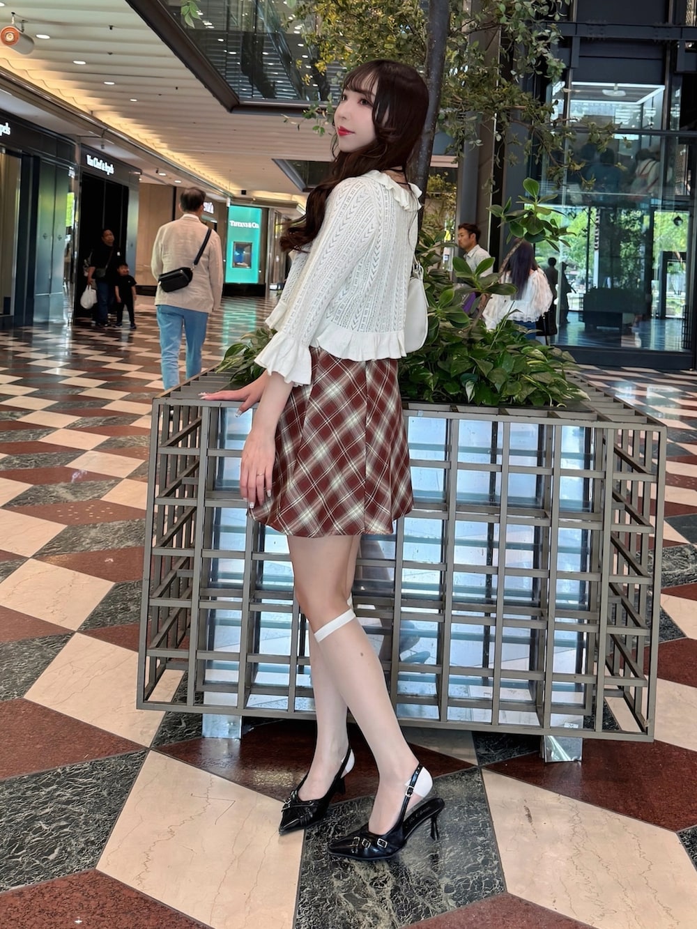 ホワイト系のカーディガン/ボレロ、ブラウン系のワンピース、ホワイト系のハンドバッグを着用したレディースの春コーディネートの3枚目の写真