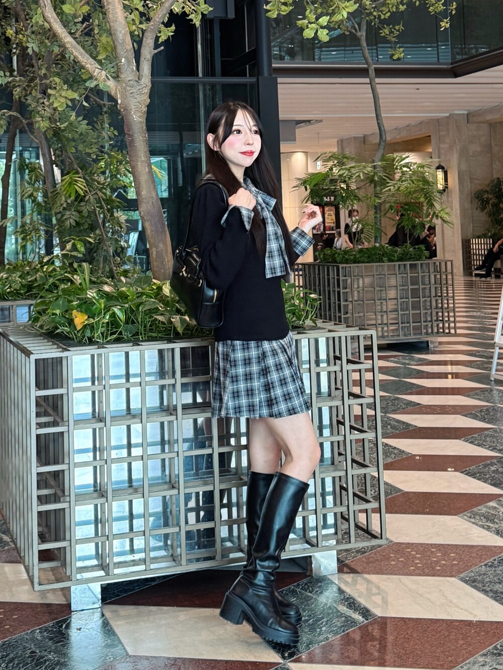 ブラック系のワンピース、ブラック系のハンドバッグを着用したレディースの秋コーディネートの4枚目の写真