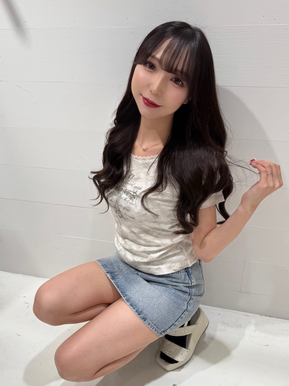 ホワイト系のTシャツ/カットソー、ブルー系のスカート、ホワイト系のサンダルを着用したレディースの夏コーディネートの2枚目の写真