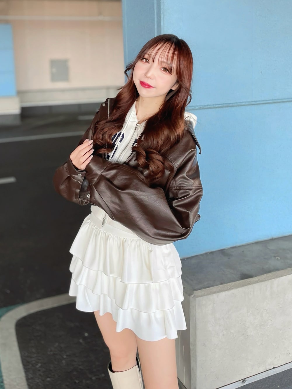 ホワイト系のスウェット、ブラウン系のブルゾン、ホワイト系のスカートを着用したレディースの冬コーディネートの3枚目の写真