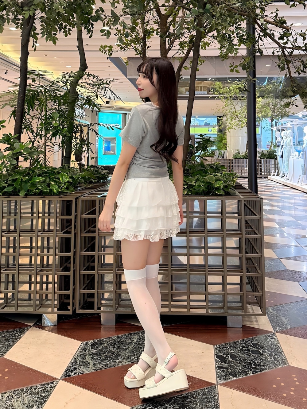 グレー系のTシャツ/カットソー、ホワイト系のスカート、ホワイト系のサンダルを着用したレディースの夏コーディネートの2枚目の写真