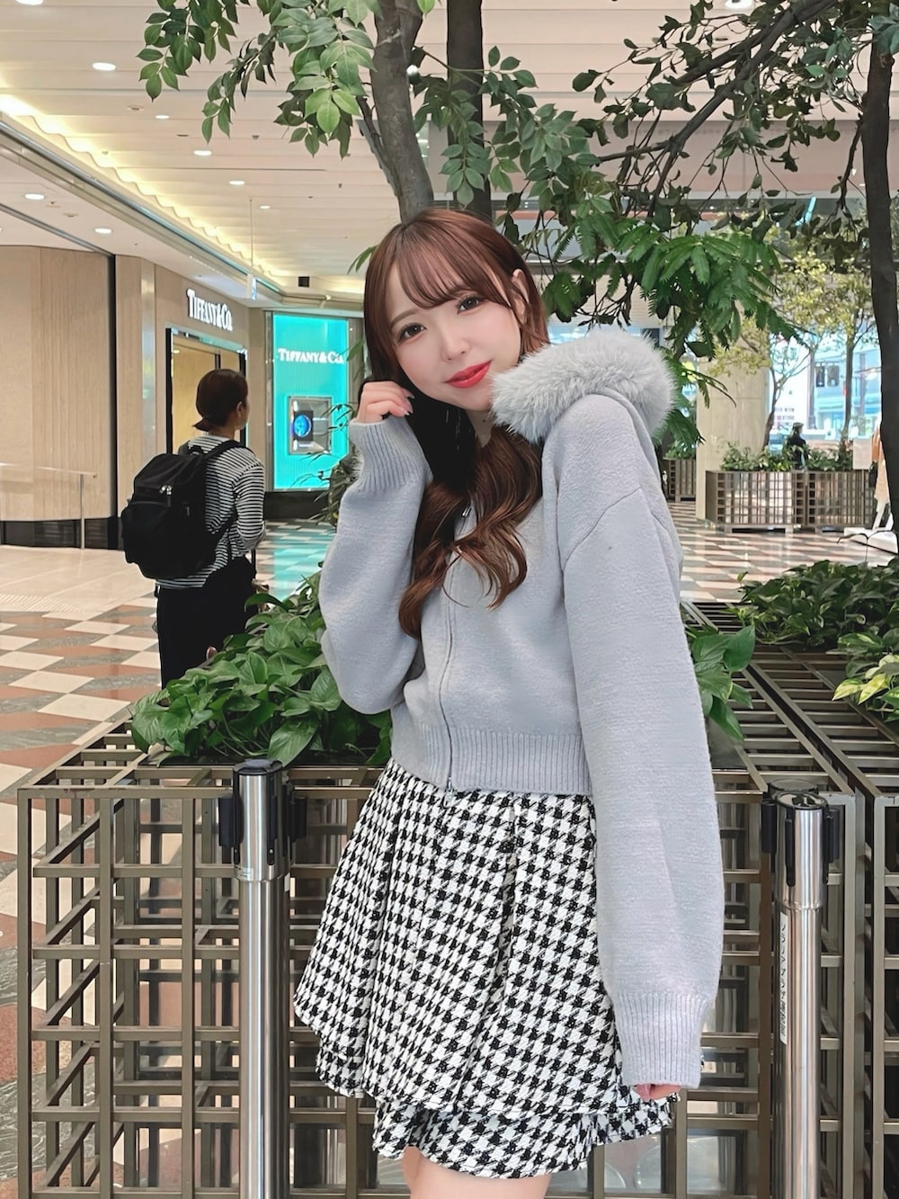 グレー系のパーカー、その他のスカート、ブラック系のブーツを着用したレディースの秋コーディネートの2枚目の写真