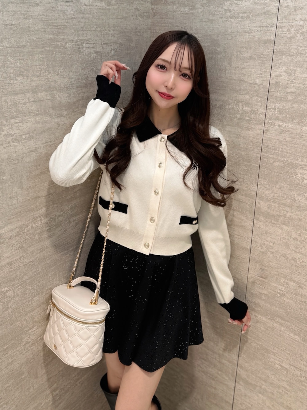 ホワイト系のカーディガン/ボレロ、ブラック系のスカート、ホワイト系のショルダーバッグを着用したレディースの春コーディネートの3枚目の写真