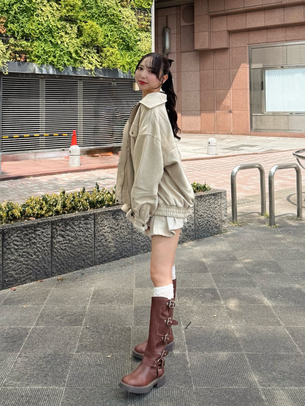 ホワイト系のブルゾン、ホワイト系のキャミソール、ホワイト系のスカートを着用したレディースの秋コーディネートの2枚目の写真