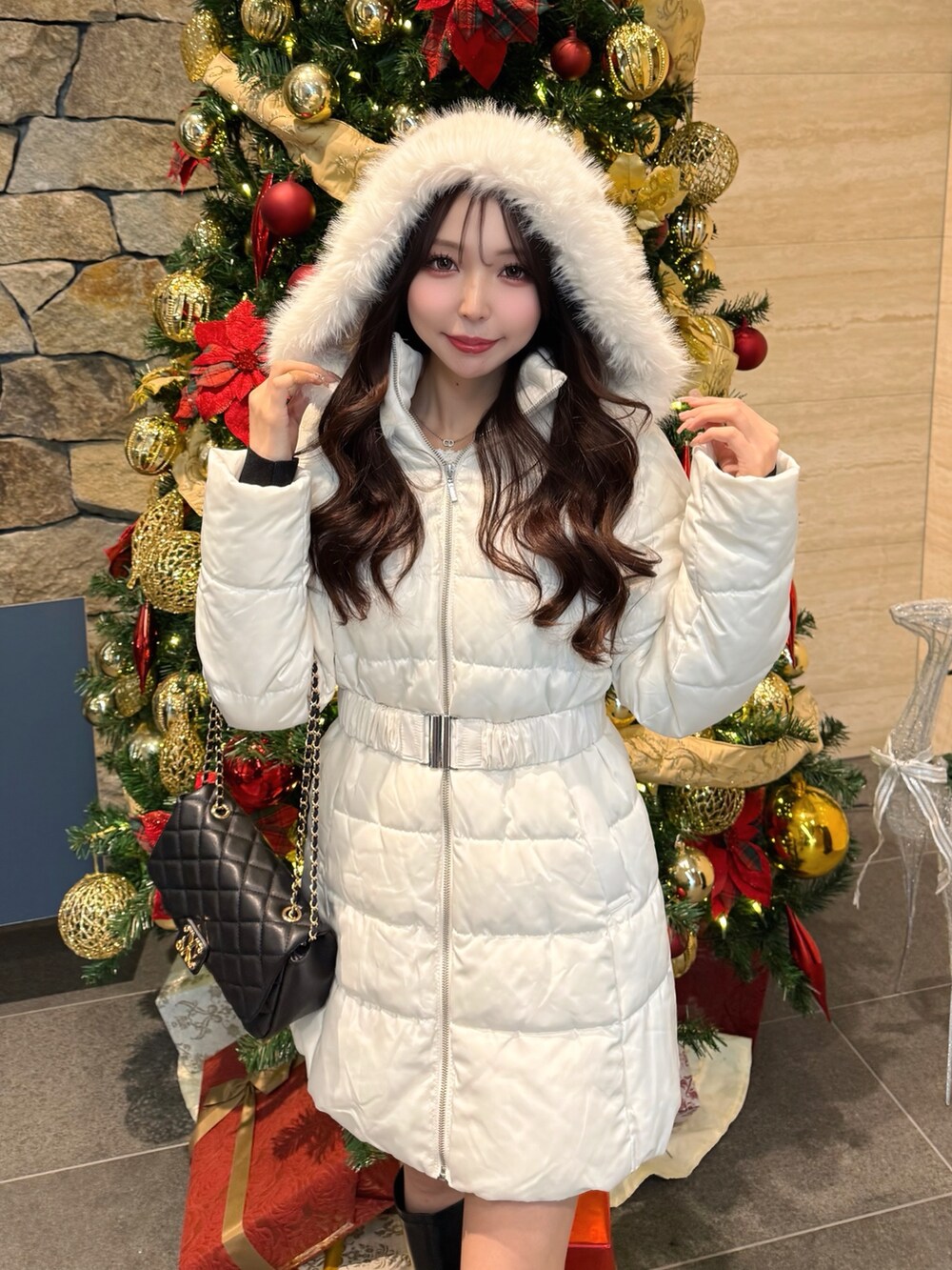 ホワイト系のダウンジャケット/コート、ブラック系のショルダーバッグを着用したレディースの冬コーディネートの3枚目の写真