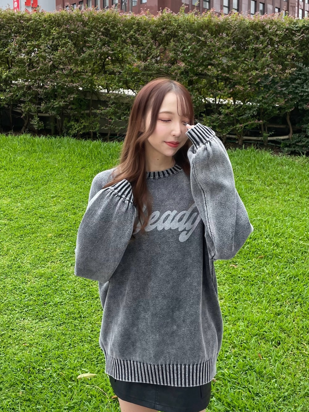 ブラック系のスカート、グレー系のニット/セーターを着用したレディースの秋コーディネートの2枚目の写真