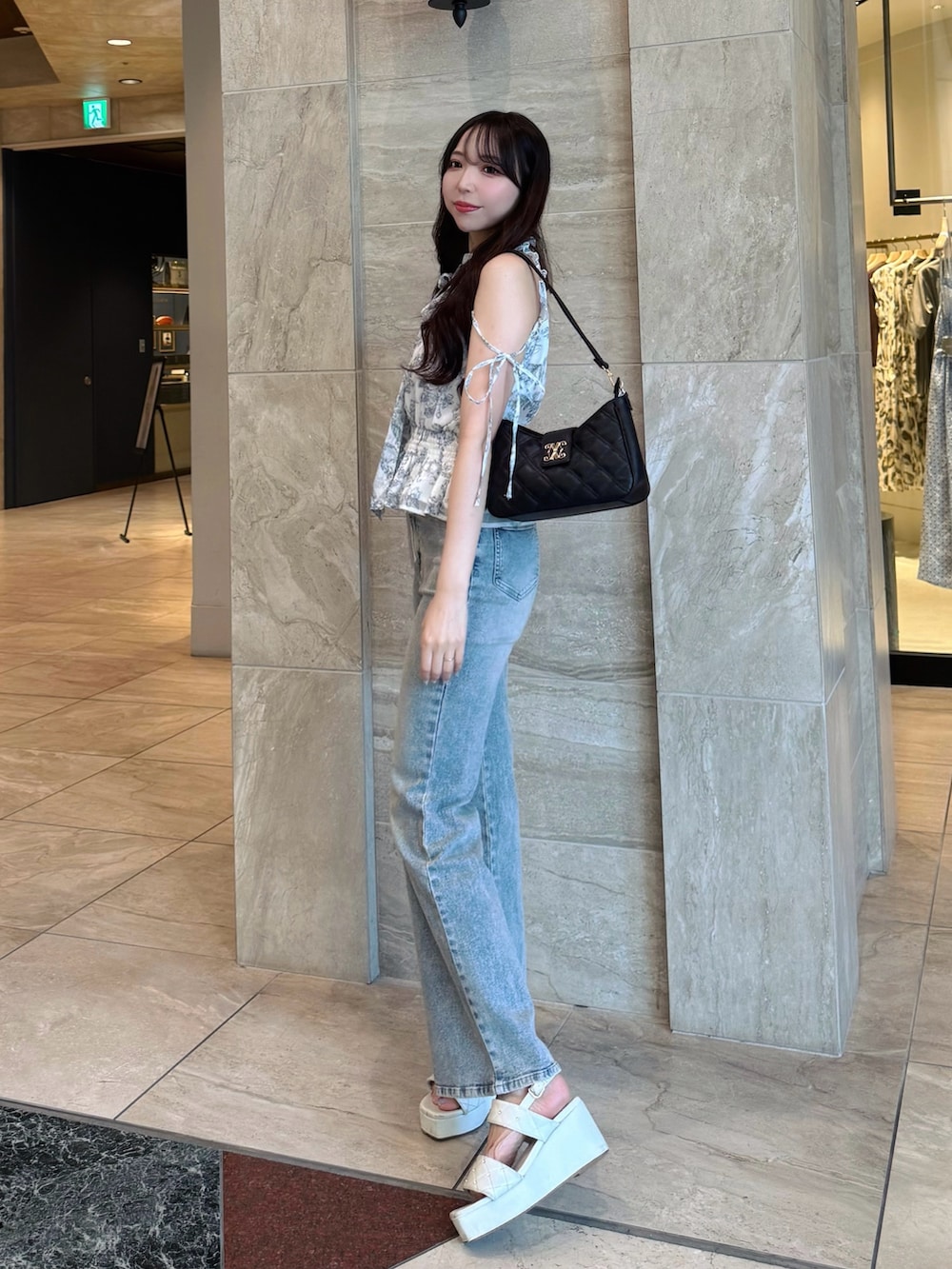 ブルー系のデニムパンツ、ホワイト系のシャツ/ブラウス、ホワイト系のサンダルを着用したレディースの夏コーディネートの5枚目の写真