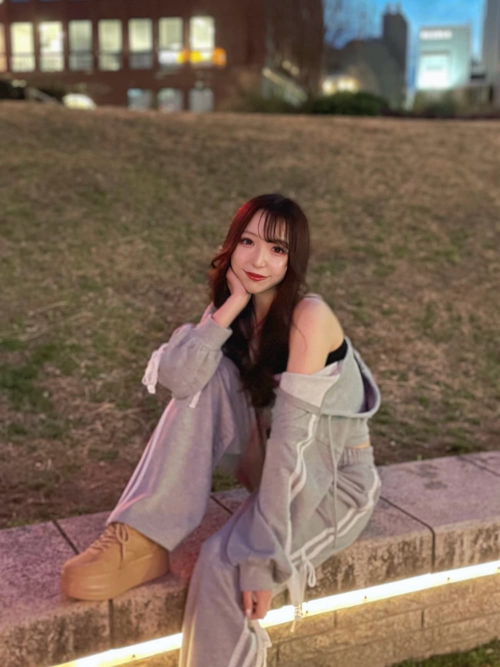 グレー系のパーカー、グレー系のスウェットパンツ、ベージュ系のスニーカーを着用したレディースの春コーディネートの2枚目の写真