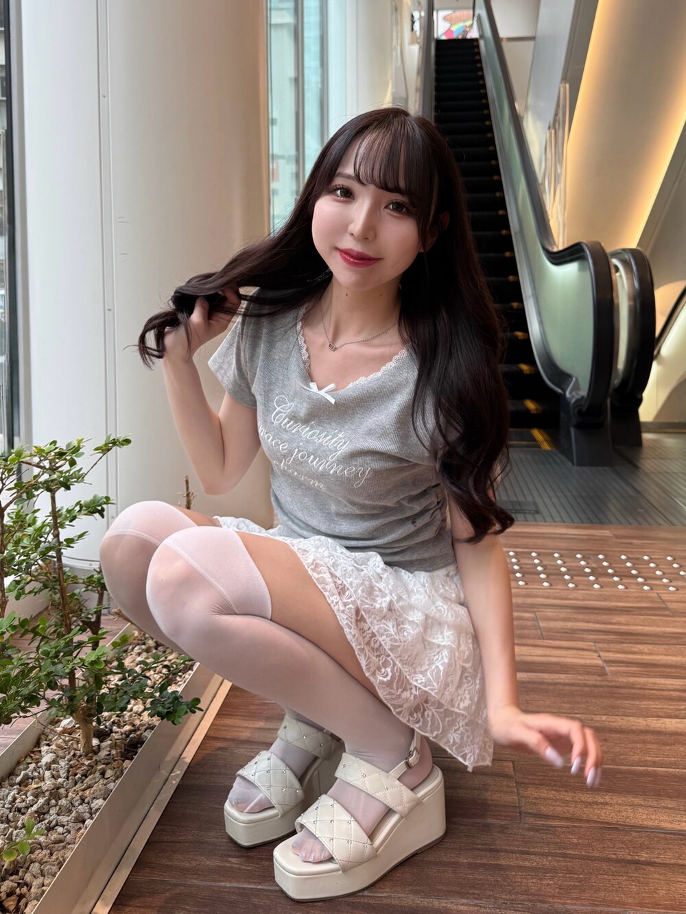 グレー系のTシャツ/カットソー、ホワイト系のスカート、ホワイト系のサンダルを着用したレディースの夏コーディネートの3枚目の写真