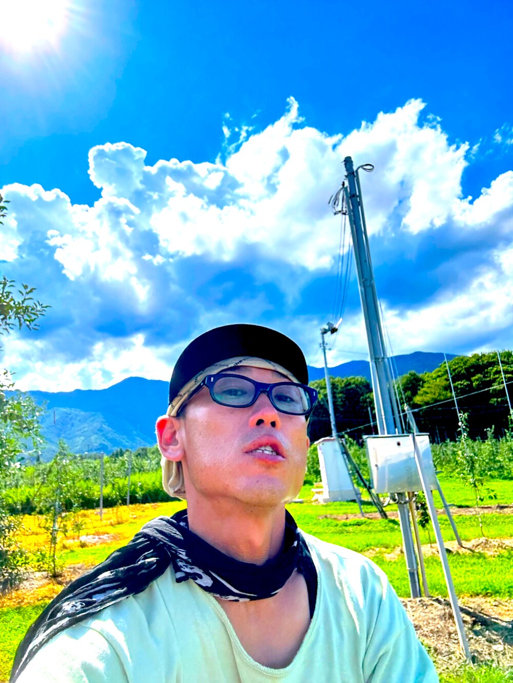 グレー系のサンダル、ブルー系のその他パンツ、グリーン系のTシャツ/カットソーを着用したメンズの夏コーディネートの2枚目の写真