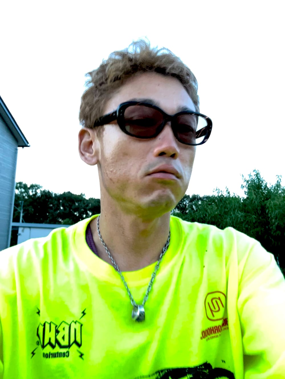 イエロー系のTシャツ/カットソー、グリーン系のカーゴパンツ、ブラック系のスニーカーを着用したメンズの秋コーディネートの4枚目の写真