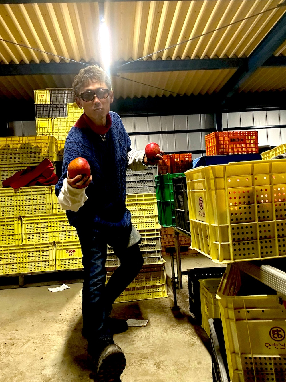 レッド系のダッフルコート、ブルー系のニット/セーター、ブルー系のデニムパンツを着用したメンズの秋コーディネートの4枚目の写真