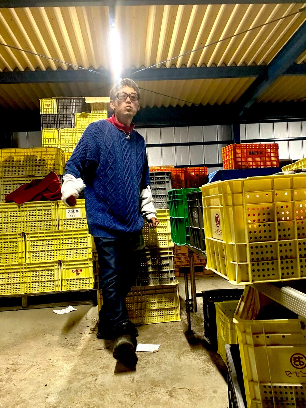 レッド系のダッフルコート、ブルー系のニット/セーター、ブルー系のデニムパンツを着用したメンズの秋コーディネートの3枚目の写真