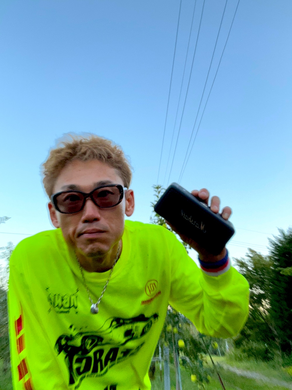 イエロー系のTシャツ/カットソー、グリーン系のカーゴパンツ、ブラック系のスニーカーを着用したメンズの秋コーディネートの3枚目の写真