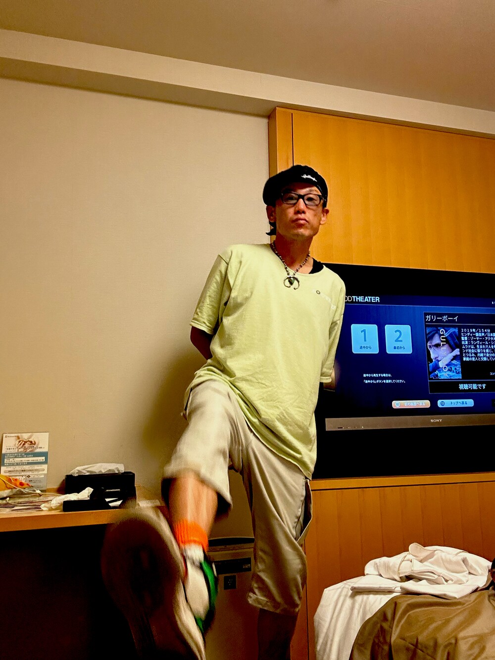 その他のスニーカー、グレー系のパンツ、グリーン系のTシャツ/カットソーを着用したメンズの夏コーディネートの2枚目の写真