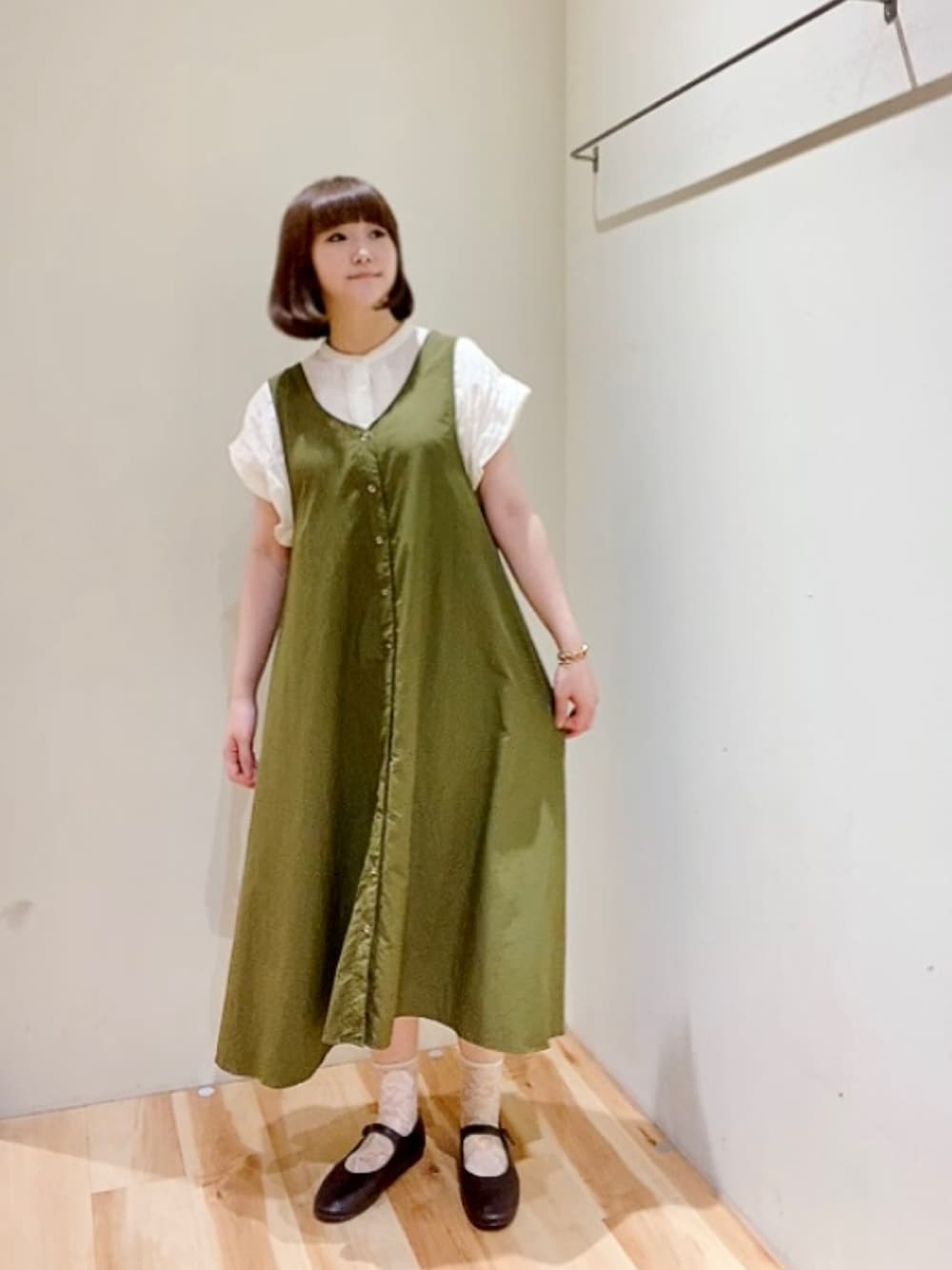 ホワイト系のシャツ/ブラウス、グリーン系のワンピース、ブラウン系のドレスシューズを着用したレディースの夏コーディネートの2枚目の写真