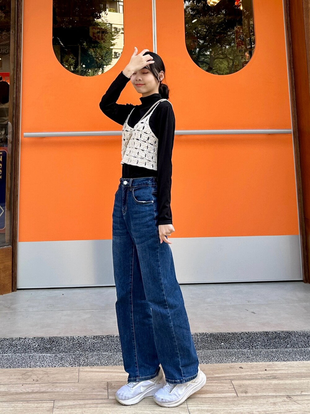 ブルー系のデニムパンツ、ホワイト系のスニーカーを着用したレディースの春コーディネートの2枚目の写真