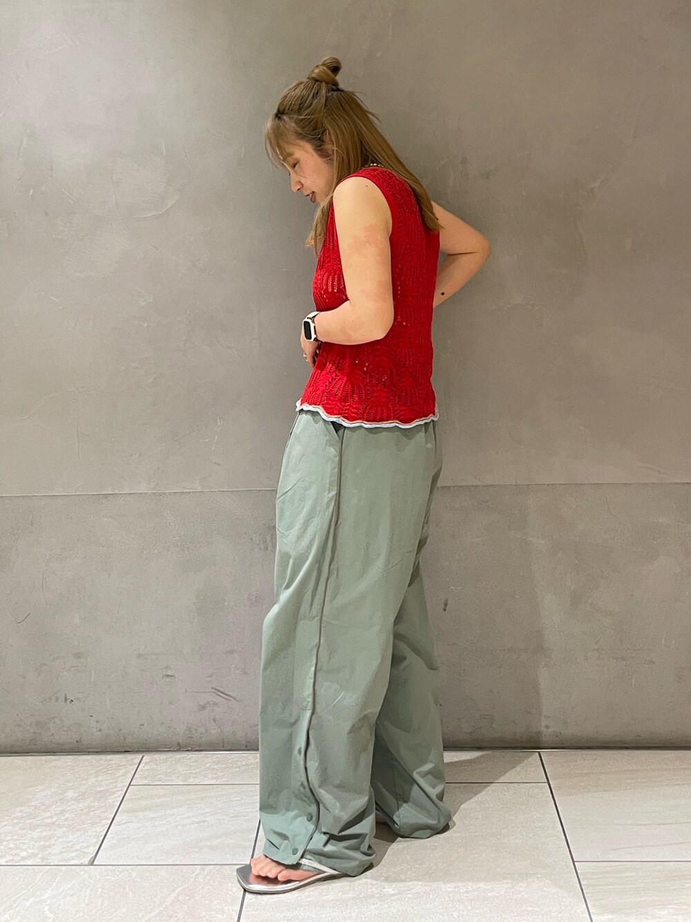 グリーン系のその他パンツ、レッド系のニット/セーター、ホワイト系のキャミソールを着用したレディースの春コーディネートの3枚目の写真