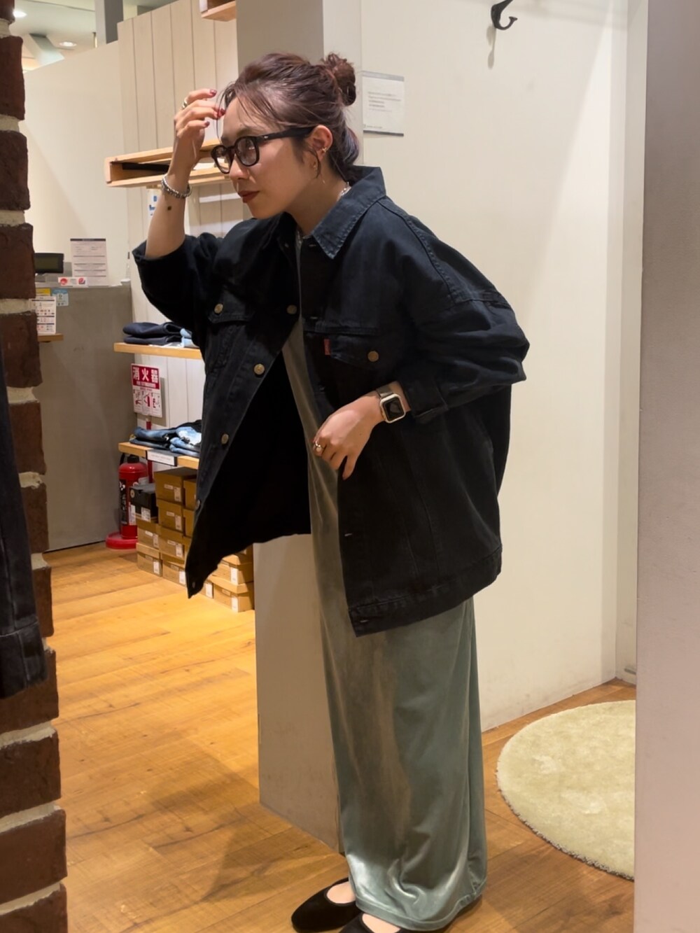グリーン系のワンピース、ブラック系のデニムジャケット、ブラック系のメガネを着用したレディースの秋コーディネートの3枚目の写真
