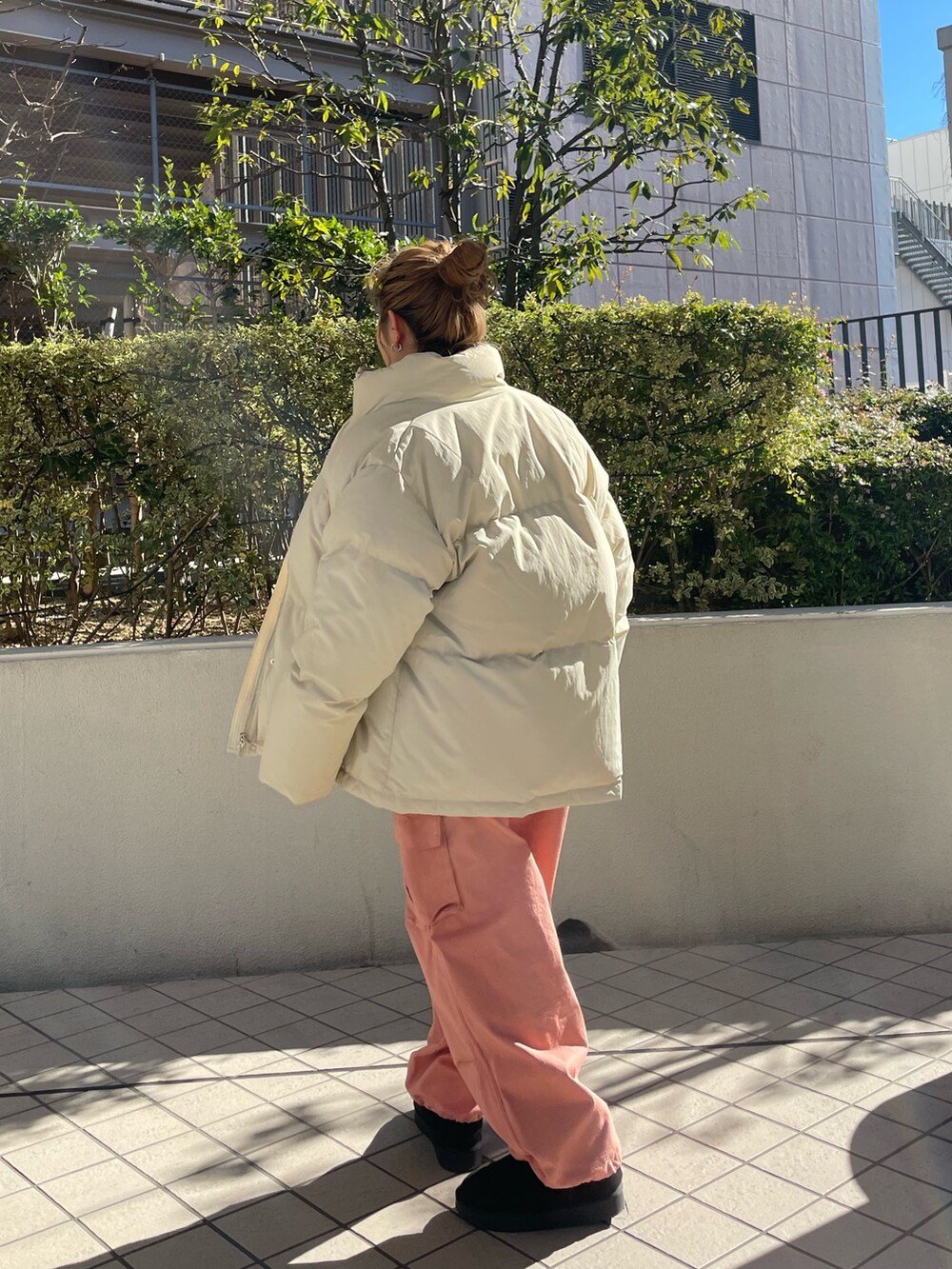 グレー系のニット/セーター、ホワイト系のダウンジャケット/コート、ピンク系のカーゴパンツを着用したレディースの冬コーディネートの3枚目の写真