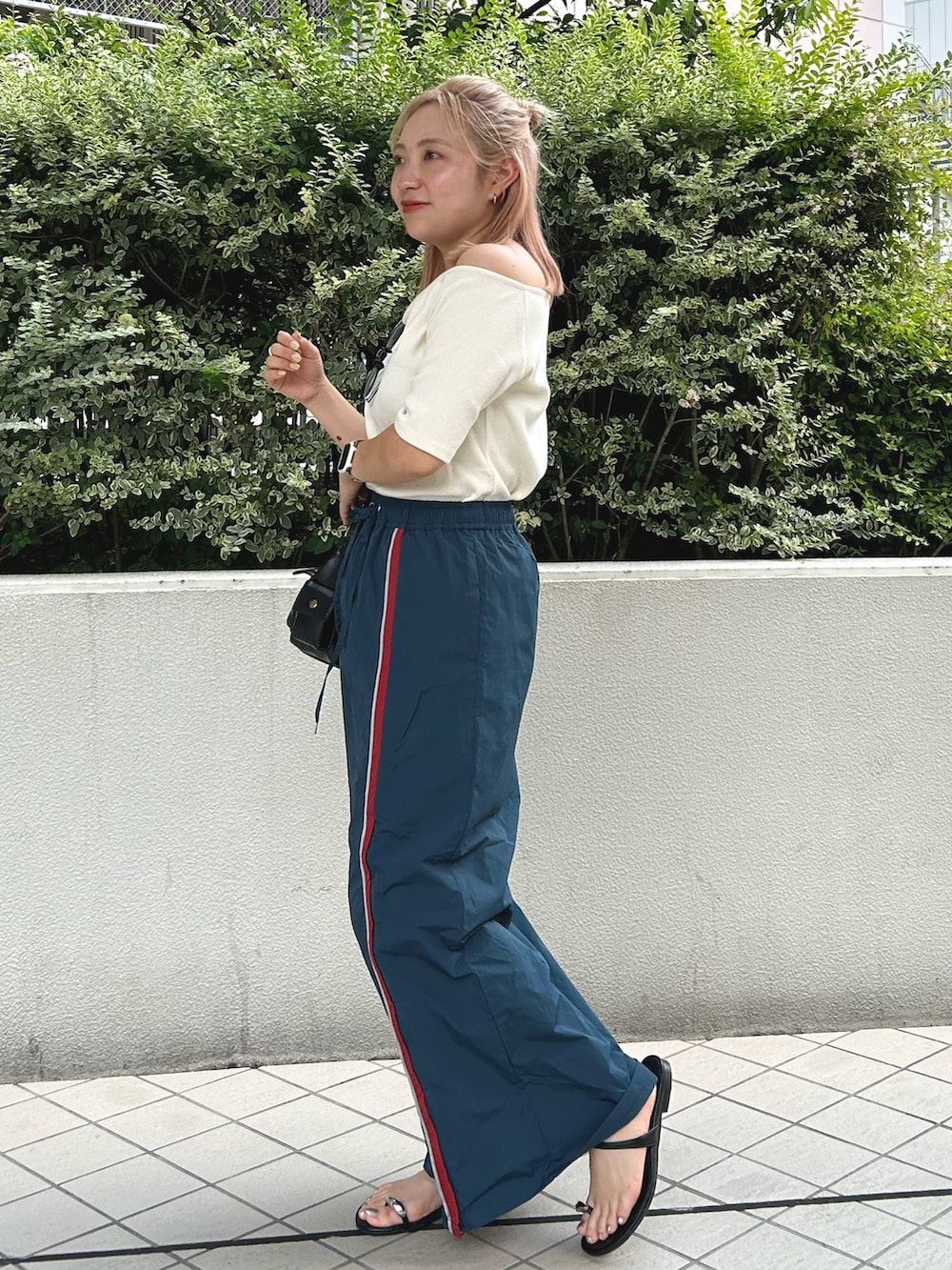 ホワイト系のTシャツ/カットソー、ブルー系のスカート、ブラック系のハンドバッグを着用したレディースの夏コーディネートの2枚目の写真