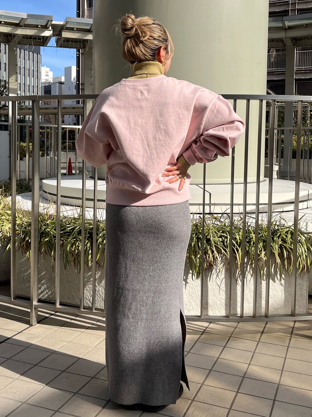 グレー系のスカート、ピンク系のスウェット、ホワイト系のブルゾンを着用したレディースの冬コーディネートの6枚目の写真